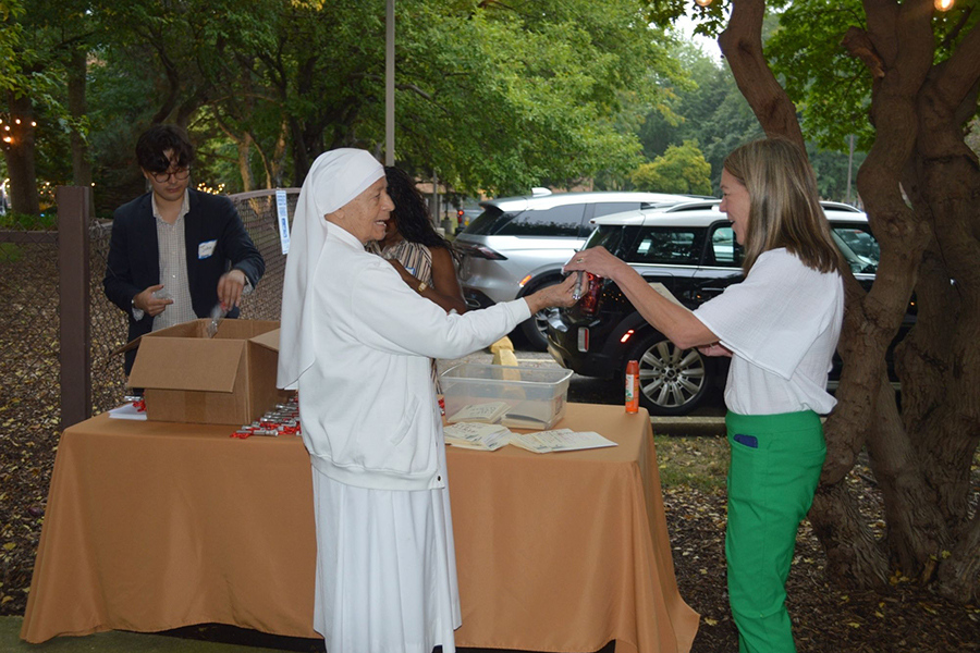 CSM Wine Tasting 2026 Photos - Sr Maria Guadalupe handing programs