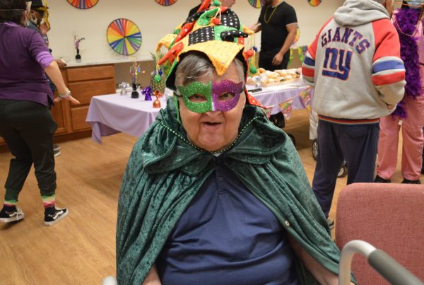 man with mardi gras mask and cape